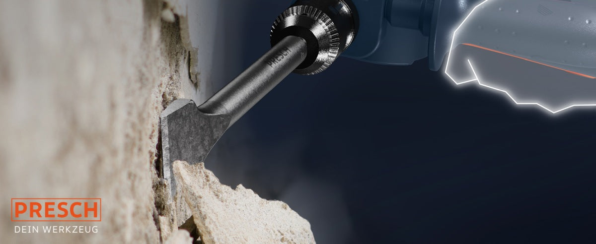 PRESCH Breitmeissel in Aktion mit einem Bohrhammer beim Meißeln in einer Wand, Flachmeißel und Spitzmeißel Werkzeug.