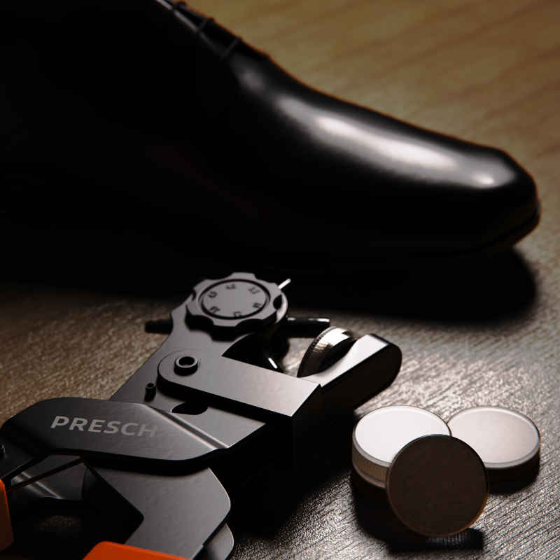 Lochwerkzeug von Presch zum Löcher stanzen neben Leder Schuh auf Holzoberfläche.